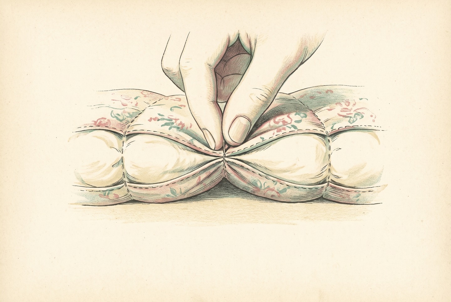 Two fingers pinch the stitched seam of a sewn-through comforter, where the fill thins to a narrow line between two filled pockets on either side.